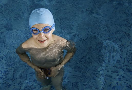 Little boy in swimming pool. Blue swimming pool.