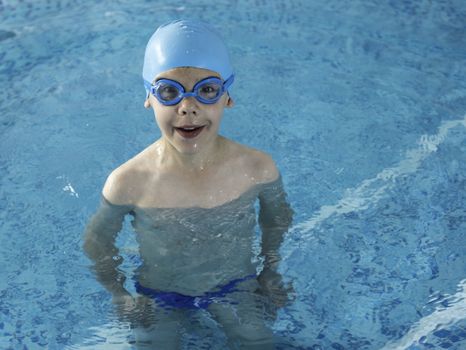 Little boy in swimming pool. Blue swimming pool.