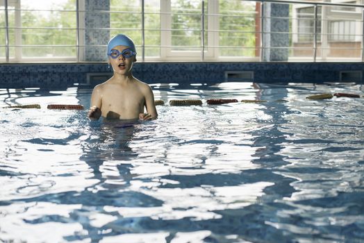 Little boy in swimming pool. Blue swimming pool.