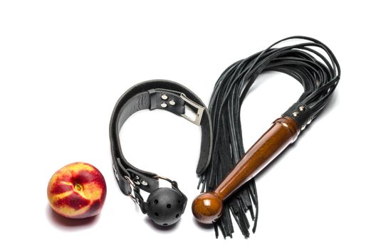 bdsm leather black gag whip and ripe peach fruit on white background