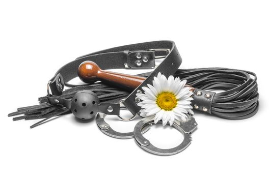 bdsm black leather gag with handcuffs and a yellow daisy flower on a white background
