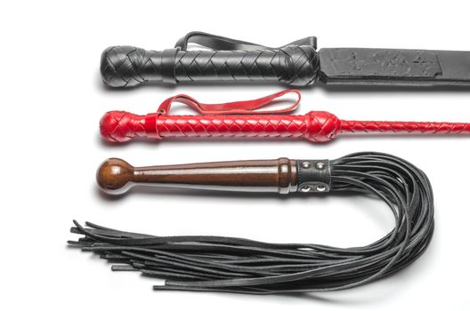 black and red three bdsm whips on a white background close up
