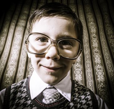 Smiling child with glasses in vintage clothes. Close up shot