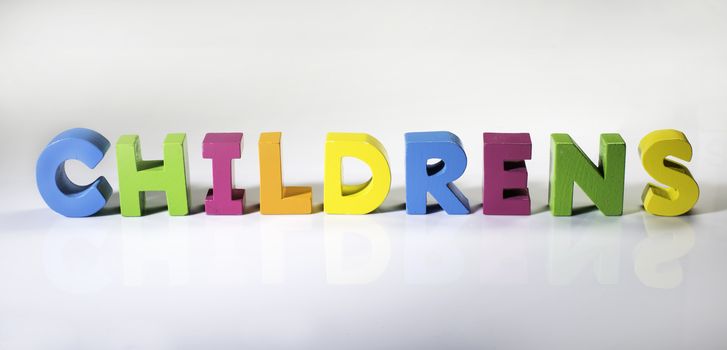 Multicolored text childrens made of wood. White background