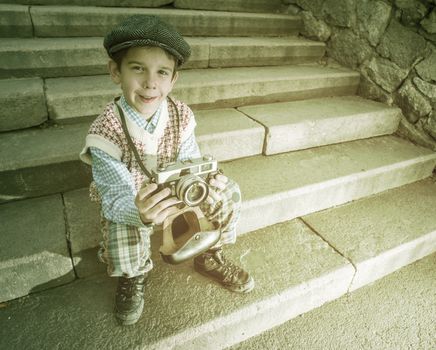 Child with vintage camera. Exterior stairs