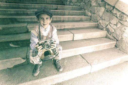 Child with vintage camera. Exterior stairs