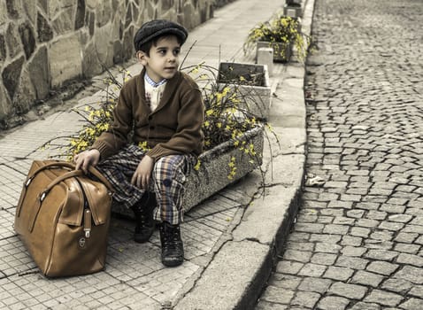 Child on a road with vintage bag. Vintage clothes style