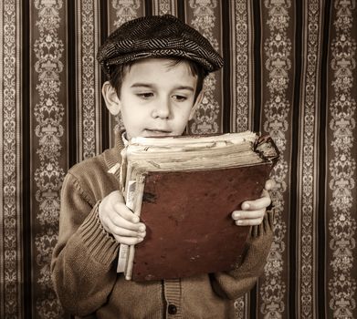 Child with red vintage book. Vintage clothes and hat