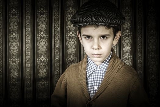 Frowning child in vintage clothes and hat. Close up shot