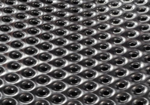 texture metal surface with a round perforation macro closeup