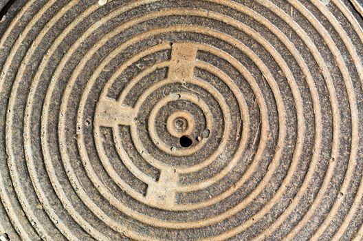 beige concentric round texture cast-iron hatch cover of brown rusty color