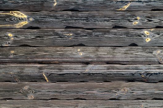 texture of a dark wooden wall with knots