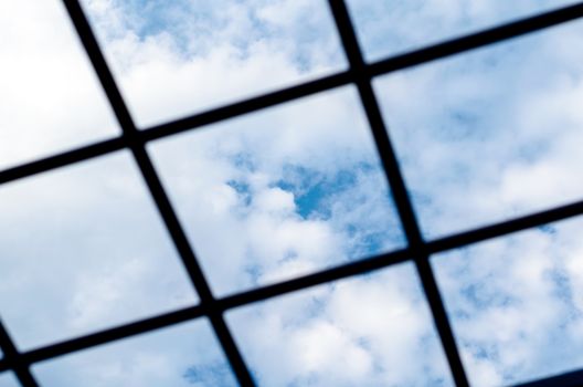 metal grille against the blue sky and white clouds close-up