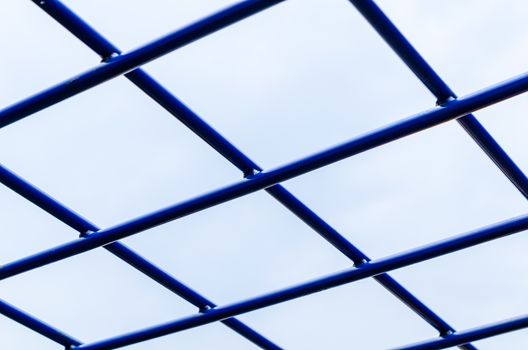 blue metal grill on blue sky background close-up