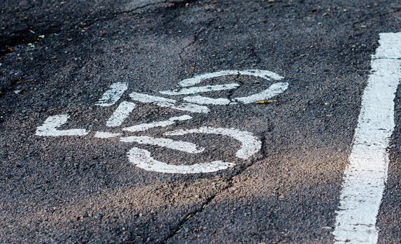 drawing a bicycle with white paint on the bike path asphalt