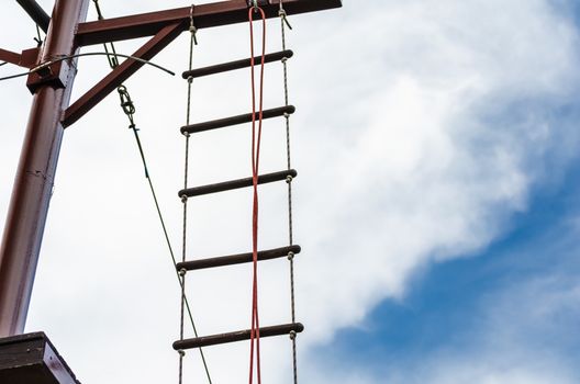 rope ladder against a blue sky and clouds