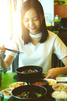 beautiful young asian girl eating korean food for lunch in a restaurant.
