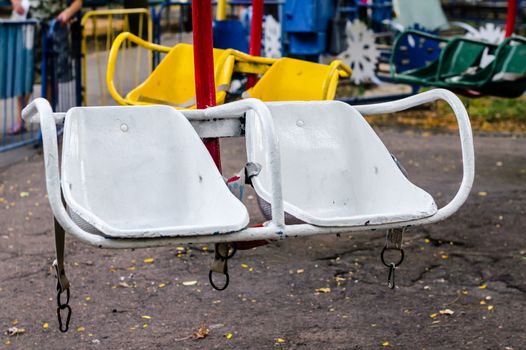old white carousel seats in the amusement park