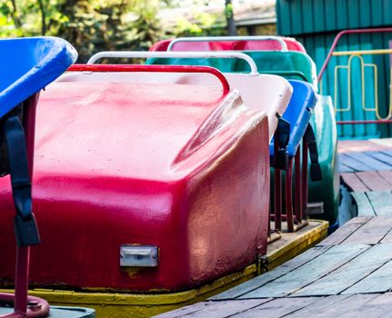 old multi-colored attraction trailers american roller coaster in amusement park