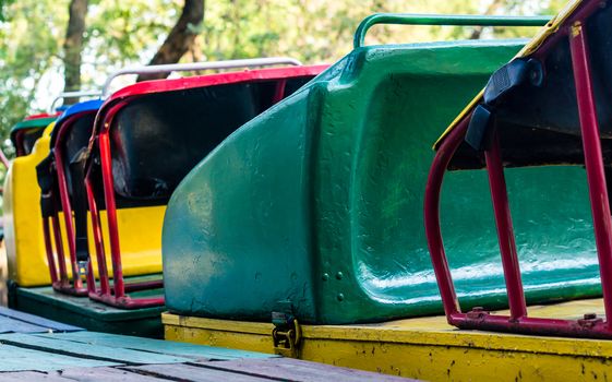 old multi-colored attraction trailers american roller coaster in amusement park