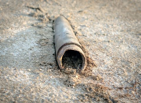 old dry dirty trumpet sticks out of the ground