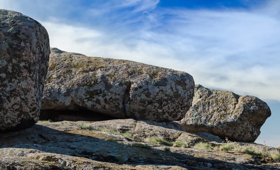 large stones against a blue sky and white clouds