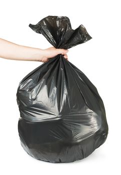 Hand holding black bag of rubbish. White isolated studio shot.