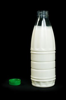 Plastic transparent bottle with milk. Green cap. Black isolated