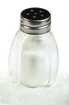 Salt and saltshaker on white background .