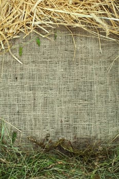 Straw and hay on burlap, copy space. Studio shot.