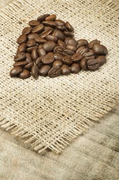 Heart made ​​of coffee beans on burlap