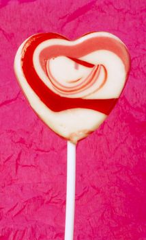 Pink lollipop heart-shaped white isolated. Studio shot