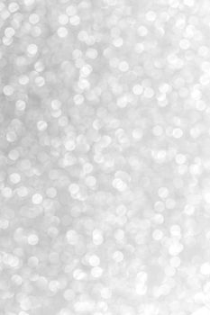 Silver festive glitter background with defocused lights
