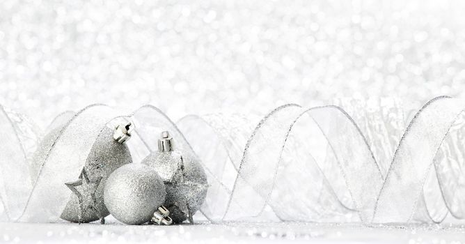 Silver christmas balls and stars on silver glitter background
