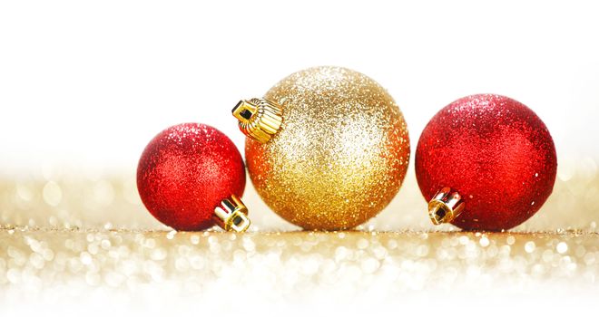 Three chritmas balls on glitters isolated on white background