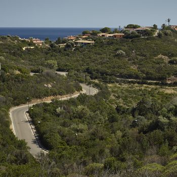 View of the hills overlooking the sea of Costa Rei in the south of Sardinia, with above them the villas used as summer residences for tourists who visit this place.