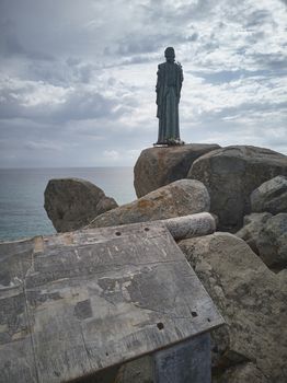View of the Scoglio di Peppino in the south of Sardinia with its statue of Christ looking towards the sea.