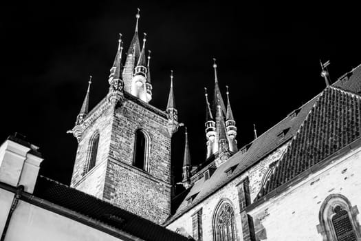 Two gothic towers of Church Of Our Lady Before Tyn at Old Town Square by night. Prague, Czech Republic. Black and white image.
