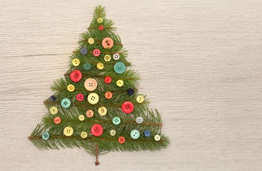 Christmas Tree Made With Pine Branches And Buttons on Wooden Table