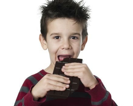 Smiling little boy eating chocolate. White isolated