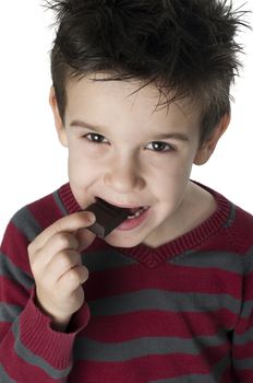 Smiling little boy eating chocolate. White isolated