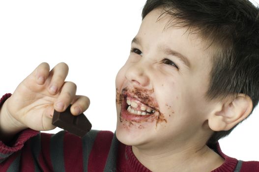Smiling kid eating chocolate. Smeared stained with chocolate lips. White isolated