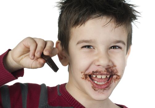 Smiling kid eating chocolate. Smeared stained with chocolate lips. White isolated