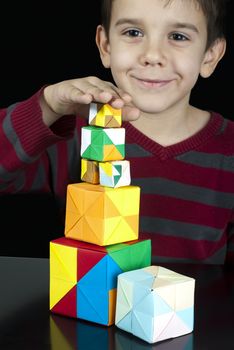 Little boy playing with multicolored cubes.