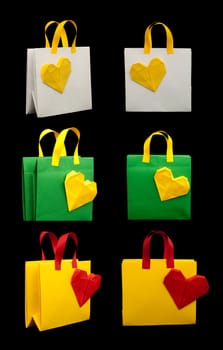 Green, yellow and white shopping bags with heart. Isolated origami