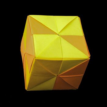 Paper made multi colored patterned cubes folded origami style. Yellow and orange colors