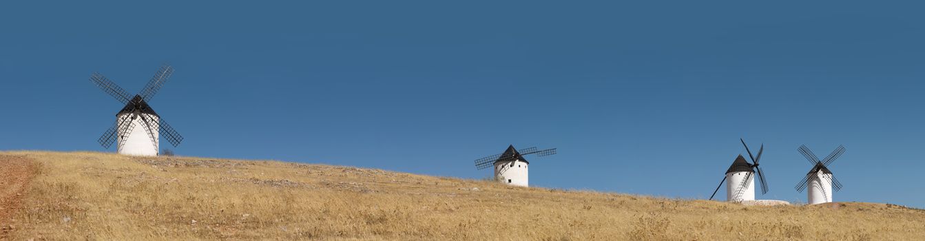 White ancient windmills. Blue sky background