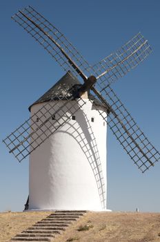 White ancient windmill. Blue sky background