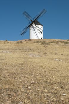 White ancient windmill. Blue sky background