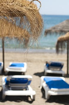 Straw beach umbrellas and sunbeds on the beach